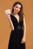 Jeune femme en portant en jouant cartes contre une Orange Contexte. studio coup photo