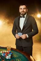 une Jeune homme dans une affaires costume permanent près poker tableau. homme des jeux de hasard. photo