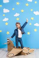 peu enfant fille dans une du pilote costume est en jouant et rêver de en volant plus de le des nuages. photo