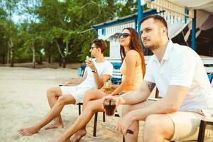 Jeune gens profiter été vacances bain de soleil en buvant à plage bar photo