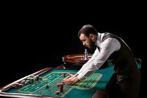 croupier derrière jeux d'argent table dans une casino. photo