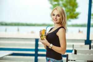 blond fille sur une été terrasse dans une bar les boissons cocktail photo