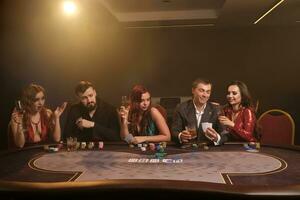 groupe de une Jeune riches copains sont en jouant poker dans casino. photo