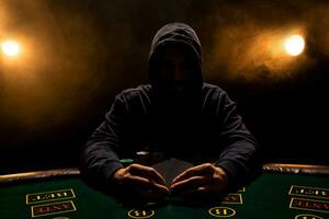 portrait de une professionnel poker joueur séance à tisonniers table photo