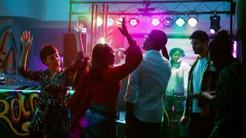 diverse les personnes sauter sur Danse sol, ayant amusement avec froussard breakdance bataille à boîte de nuit. de bonne humeur Hommes et femmes profiter dansant fête avec électronique dj musique. ordinateur de poche tir. photo