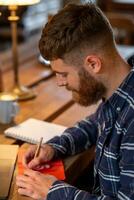 décontractée affaires homme ou pigiste Planification le sien travail sur carnet de notes, travail sur portable ordinateur avec intelligent téléphone, tasse de café sur table à café magasin ou Accueil bureau. photo