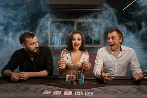 groupe de une Jeune riches copains sont en jouant poker dans casino. photo