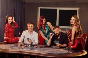 groupe de une Jeune riches copains sont en jouant poker dans casino. photo