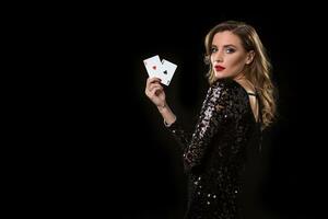Jeune femme en portant en jouant cartes contre une noir Contexte photo