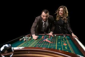 homme avec femme en jouant roulette à le casino. dépendance à le photo