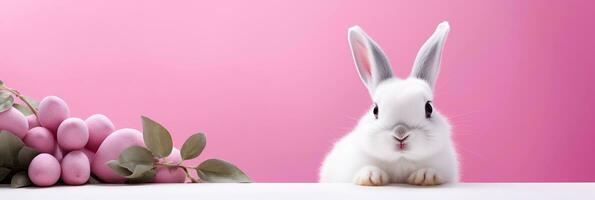 ai généré charmant duveteux animal de une Jeune lapin. Pâques lapin et Pâques des œufs sur rose Contexte avec copie espace. photo