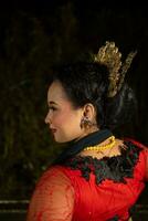 une Javanais Danseur portant une noir châle et jasmin sur sa tête tandis que dansant sur étape à nuit photo