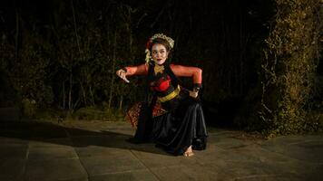 une Javanais Danseur fait du souple et écoulement mouvements dans temps avec le rythme de le la musique photo