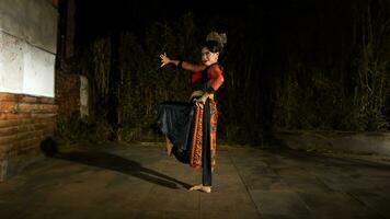 une Javanais Danseur dans une rouge costume présenté une Danse cette captivé le public avec le sien compétence photo