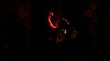 silhouette de une femelle Danseur en portant bijoux dans le milieu de le immobilité de le nuit avec rouge lumière photo