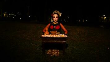 une femelle Danseur qui regards magnifique dans une rouge costume effectue une rituel cette rayonne un aura de beauté et pureté photo