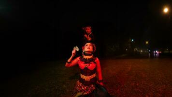 une femelle Danseur dans une rouge costume Sam dans le silence de le nuit lequel renforcé le tristesse photo