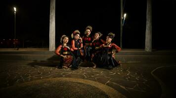 une groupe de indonésien danseurs séance très élégamment tandis que portant rouge Robes dans une Château photo