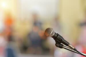 fermer de microphone sur étape pour orateur discours avec brouiller bokeh lumière Contexte. photo