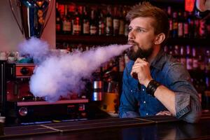 vapoter. vapoter homme dans une nuage de vapeur. photo est pris dans une vape bar.