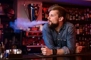 vapoter. vapoter homme dans une nuage de vapeur. photo est pris dans une vape bar.