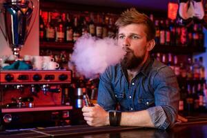 vapoter. vapoter homme dans une nuage de vapeur. photo est pris dans une vape bar.