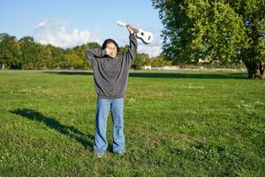 content asiatique fille, musicien avec ukulélé, sentiment insouciant, profiter liberté et Frais air en plein air, en jouant musical instrument photo