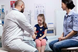 fille ayant des douleurs car de bras pendant médical vérification dans hôpital bureau. soins de santé médecin spécialiste dans médicament fournir santé se soucier prestations de service traitement examen. photo