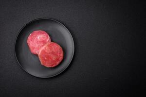 rond forme steaks de brut juteux thon avec sel et épices photo