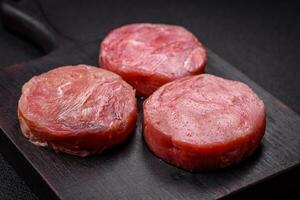 rond forme steaks de brut juteux thon avec sel et épices photo