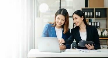 femme d'affaires de premier plan équipe réunion et en utilisant tablette et portable ordinateur avec financier dans Bureau photo