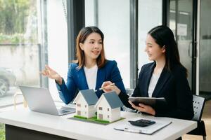 agent de courtage immobilier présentant et consultant le client pour la prise de décision signant un accord de formulaire d'assurance, modèle de maison, concernant l'offre de prêt hypothécaire photo