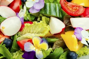 printemps salade avec des légumes et fleurs. photo