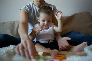 peu garçon pièces avec Jeune magnifique maman dans le chambre photo