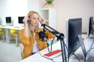 Jeune femme est diffusion tandis que séance dans cotravail à le ordinateur photo