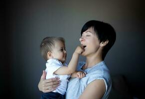 peu garçon pièces avec Jeune magnifique maman dans le chambre photo