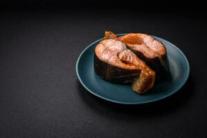 délicieux steak de saumon frais cuit avec des épices et des herbes cuites sur un gril photo