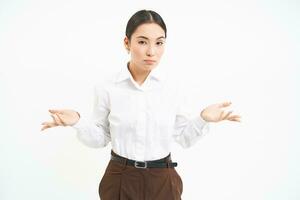 portrait de asiatique femme hausse les épaules épaules, regards confus et désemparés, des stands plus de blanc studio Contexte photo