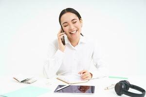 portrait de souriant femme entrepreneur parlant avec sa client sur mobile téléphone, Parlant avec Quelqu'un sur téléphone portable, blanc Contexte photo