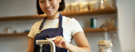 verticale coup de fille barista dans café verser l'eau de robinet, en utilisant bouilloire à brasser filtre café photo