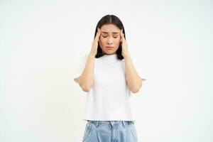 triste femme détient mains sur diriger, souffre mal de tête, a migraine, se sent vertigineux, des stands plus de blanc Contexte photo