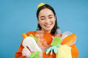 portrait de souriant asiatique femme avec Plastique ordures, en portant déchets et regards content, recueille litière pour recyclage centre, durable mode de vie concept photo