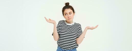 je ne pas savoir. Aucune idée Jeune femme haussant les épaules épaules, regards confus, des stands contre blanc studio Contexte photo