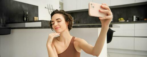 mode de vie et entraînement. moderne aptitude fille prend selfie sur yoga tapis, Est-ce que sa des exercices à Accueil et fait du Photos sur téléphone intelligent, enregistrements vivre vlog, vidéo sur téléphone