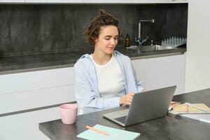 portrait de 25 ans femme, études en ligne, montres cours dans l'Internet, travaux sur portable de sa Accueil photo