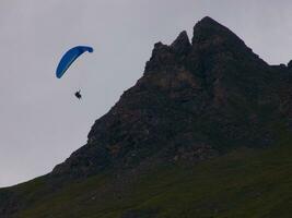 une la personne en volant une parapente plus de une Montagne photo