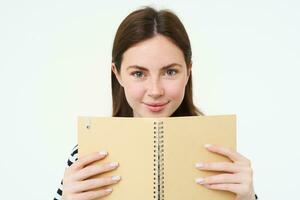 image de Jeune femme avec carnet de notes, en portant sa personnel agenda, travail planificateur, souriant, en train de lire quelque chose, permanent plus de blanc Contexte photo