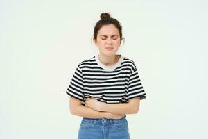 portrait de femme grimaçant de douloureux menstruel crampes, touche sa ventre, malaise ou estomac mal, des stands plus de blanc Contexte photo