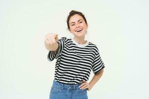 image de élégant Jeune femme, montrer du doigt doigt à caméra, attrayant toi, permanent plus de blanc Contexte photo