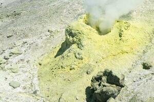 Jaune cône de cristallisé soufre autour une fumeur solfatare sur le pente de une volcan photo